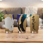 Three artistic tumblers on wooden table.